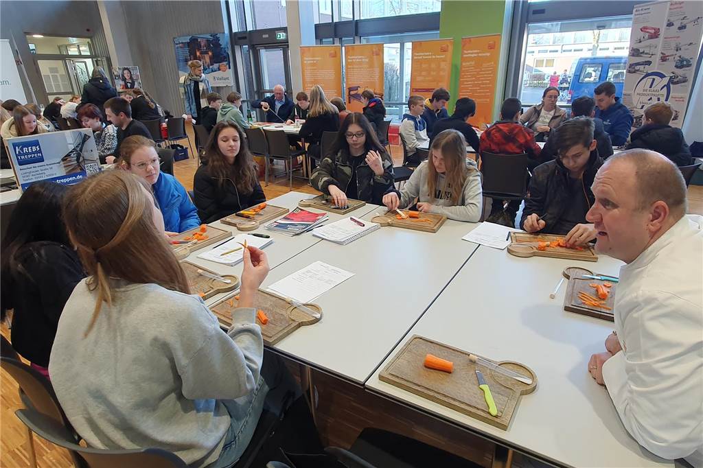 Praktikumsmesse in Profilschule bringt Schüler und Betriebe zusammen Schüler und Arbeiter sitzen ein einem Tisch und tauschen sich aus.
