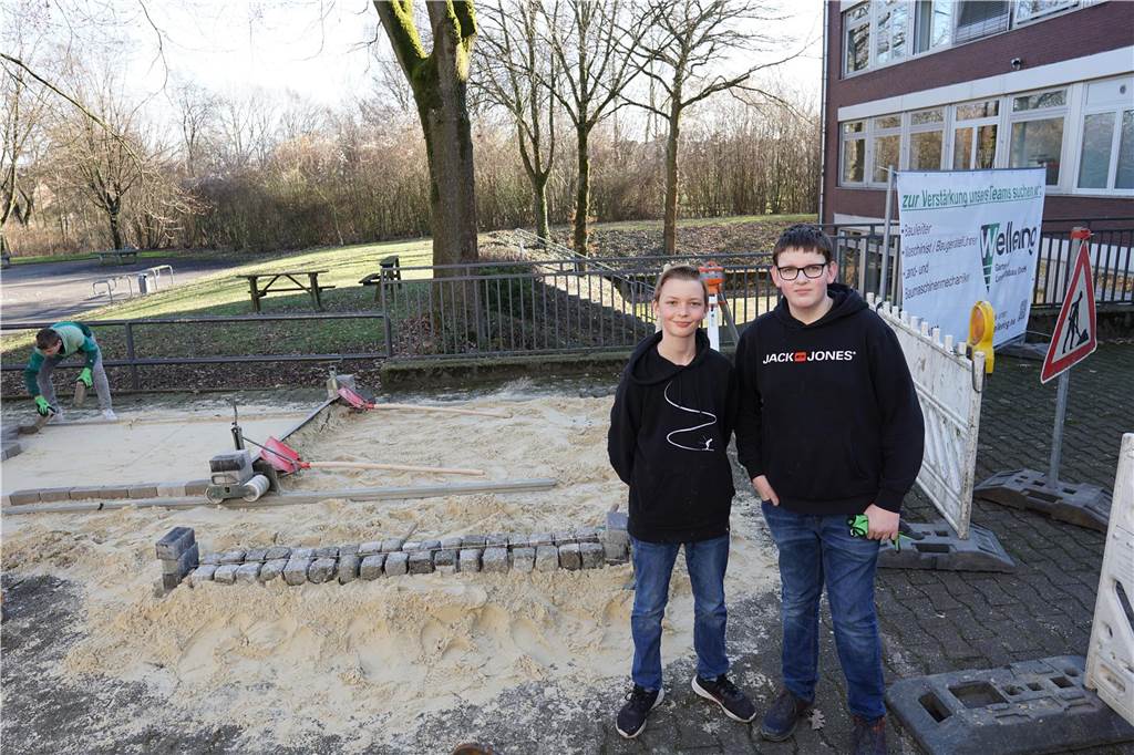 Schüler stehen vor der Schule.