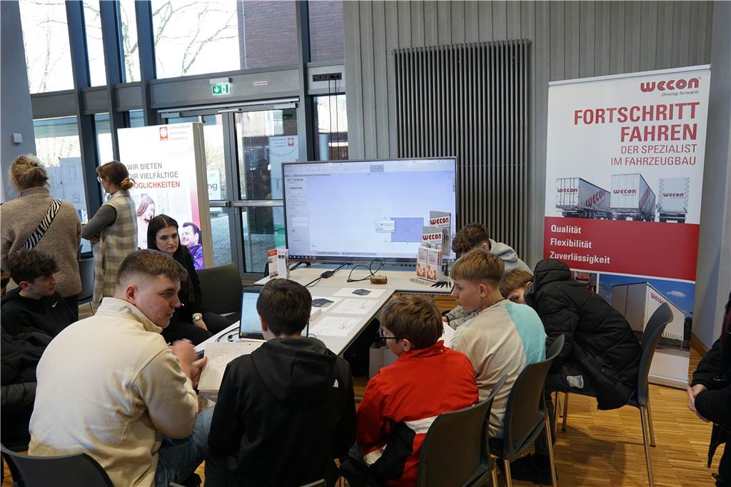Schüler sitzen an Tischen.