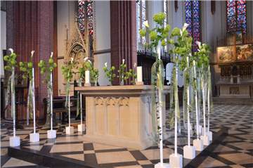 18 dekorierte Calla, aufgebunden mit Winterschneeball und Efeu, umrunden zur Erinnerung an die verstorbenen Schüler, Schülerinnen und Lehrerinnen den Altar in der Sixtus-Kirche. Calla gelten als ein Zeichen für das ewige Leben.