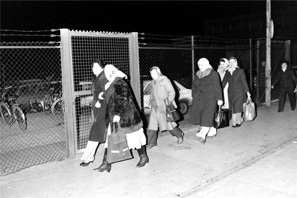 1972 als Gastarbeiterin nach Lünen: „Wir wollten ein gutes Leben haben“ schwarz-weiß: Frauen laufen entlang eines Zaunes.