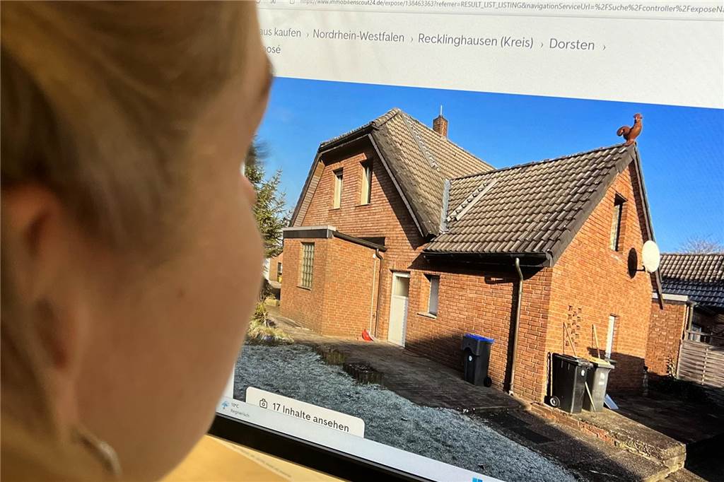 Immobilienmarkt: Wie viel Haus bekommt man für 200.000 Euro in Dorsten? Eine Frau schaut sich ein Immobilienangebot an.