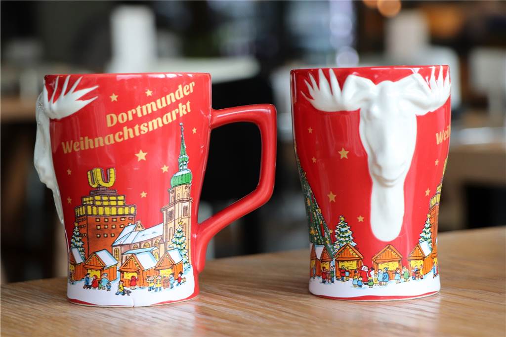 2018 war die Weihnachtstasse nach einiger Zeit wieder rot. Eine Besonderheit war der weiße Elch, der aus der Tasse hervorragt.