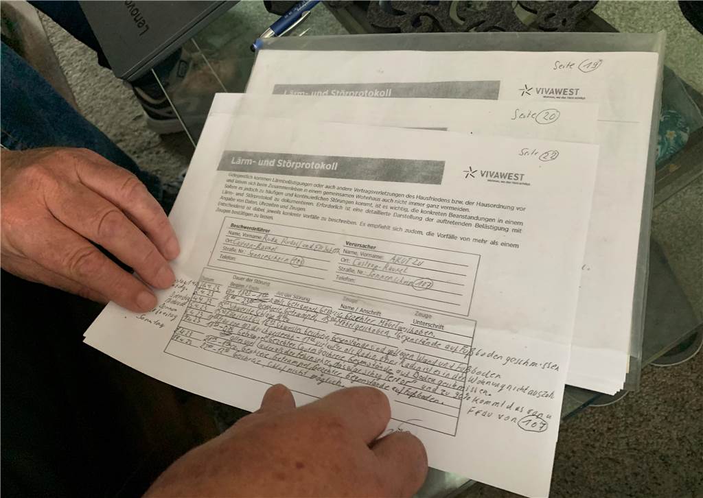 Mit den Nachbarn auf Kriegsfuß: Familie soll aus ihrem Wohnhaus raus Zu sehen sind mehrere Seiten Papier mit einem handschriftlich verfassten Protokoll.