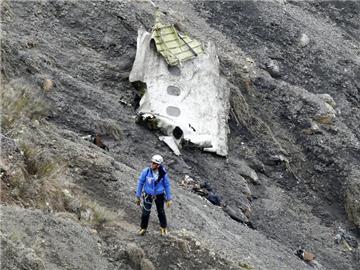 25. März: Ein Mitglied der Bergungsmannschaft vor einer Trümmerstück der Germanwings-Maschine in den französischen Alpen. Foto: Guillaume Horcajuelo