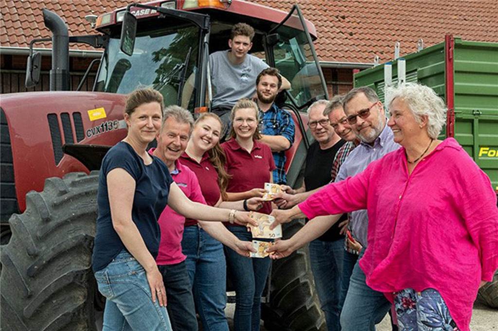 Aus verliehenem Trecker wird tolle Spendenaktion in Herbern Eine Gruppe Menschen vor einem Traktor