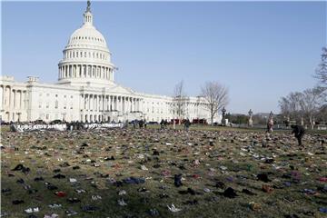 7000 Paar Kinderschuhe liegen auf dem Rasen vor dem Kapitol. Die Schuhpaare stehen jeweils für ein durch Schusswaffen getötetes Kind seit dem Amoklauf an der Sandy Hook Elementary School am 14.12.2012. Foto: Paul Morigi/AP