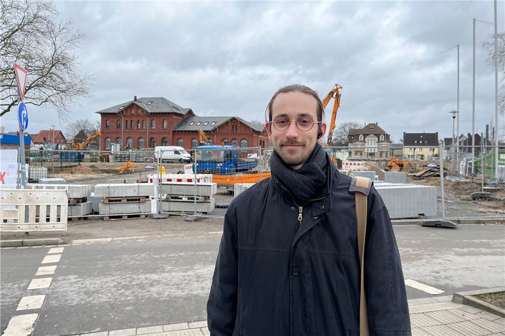 Das sagen Dorstener zum Ende der Maskenpflicht in Bus und Bahn Aaron Bittinger steht vor der Baustelle am Bahnhofsvorplatz in Dorsten. Im Hintergrund steht das Bahnhofsgebäude.