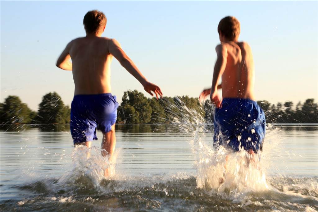 Zum Start des 49-Euro-Tickets: Ausflugsziele in der Nähe für einen Tag Zwei Jungen rennen in das Wasser eines Sees