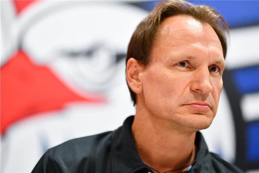 Mannheim geht ohne konkretes Saisonziel in die neue Saison Adler Mannheims Trainer Pavel Gross sitzt auf dem Podium vor einem Vereinswappen. Foto: Uwe Anspach