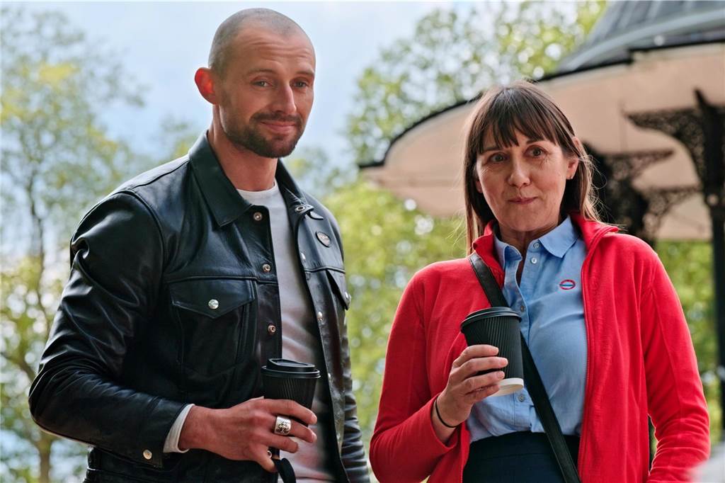 Influencer Adam und Eva stehen nebeneinander mit einem To-Go Becher in der Hand.