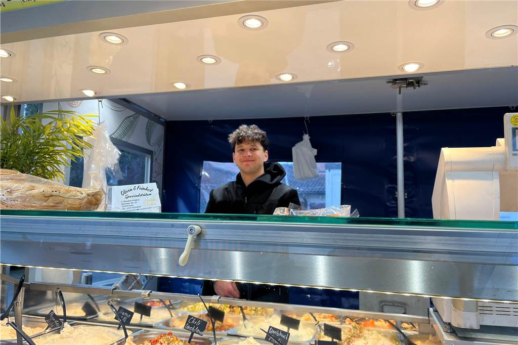 Steckt der Nordkirchener Wochenmarkt in der Krise? Junger Mann hinter Pasten und Oliven