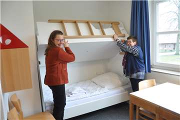 Akademie-Direktorin Antje Valentin (l.) und Bibliotheksleiterin Sabine Lahl zeigen, wie sich aus den Doppelstock-Betten bei Bedarf ein Einzelzimmer bauen lässt. 