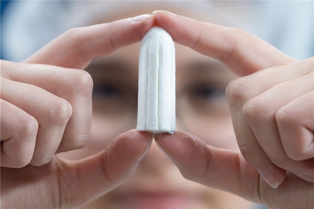 Kostenlose Menstruationsartikel an Gesamtschule: Bald könnte die Gemeinde zahlen Frau hält einen Tampon