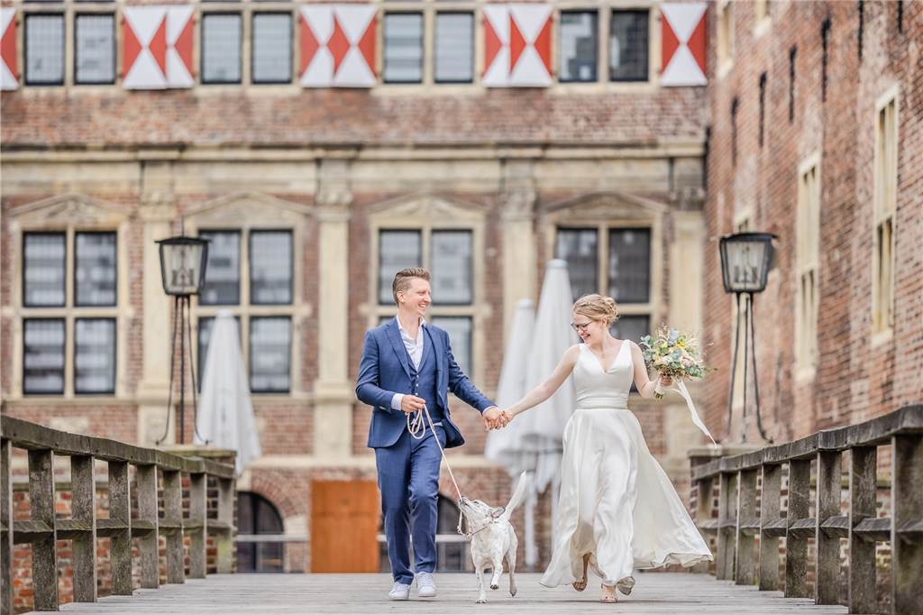 Kira und Matthias Portleroi sind die „Schlossvermählten des Jahres“ Alena und Matthias Stehl laufen mit einem Hund vor dem Schloss Raesfeld.