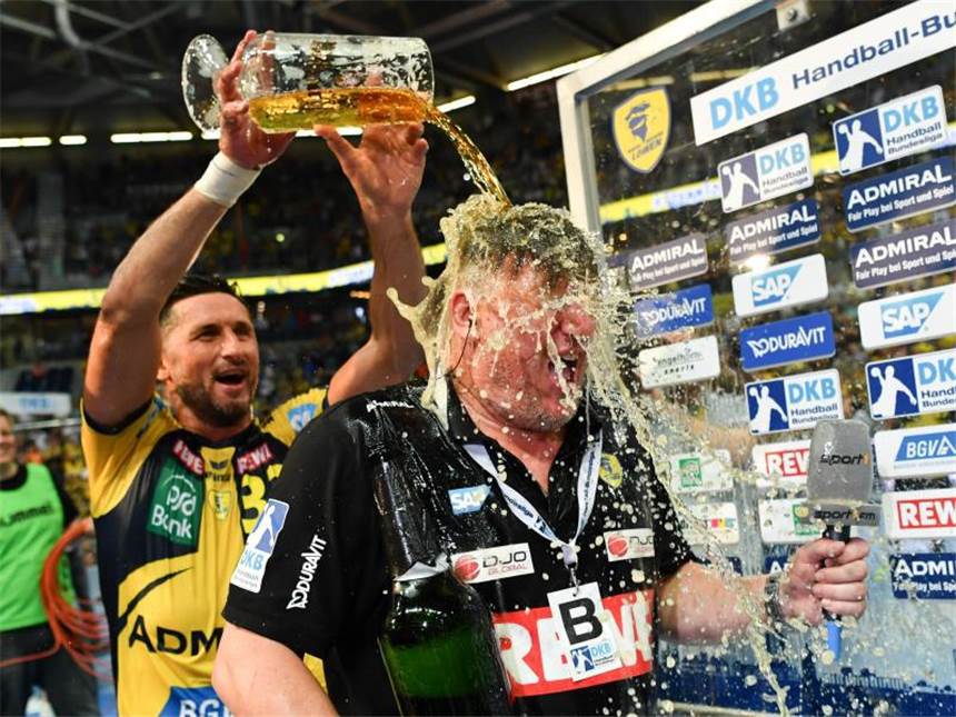 Rhein-Neckar Löwen deutscher Handball-Meister Alexander Petersson (l) von den Rhein-Neckar Löwen "beglückt" Meister-Trainer Nikolaj Jacobsen mit einer Bierdusche. Foto: Uwe Anspach