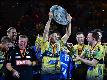 Alexander Petersson (M) hält die Meisterschale in den Händen und feiert mit seinen Mannschaftskollegen den Gewinn der deutschen Meisterschaft. Foto: Uwe Anspach