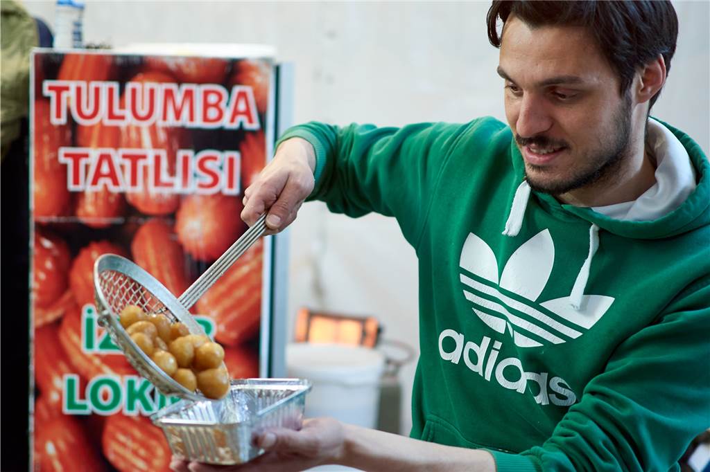 Ali Bas füllt eine frische Portion Lokma in eine Schale. Die süßen Teigbällchen werden noch warm gegessen.