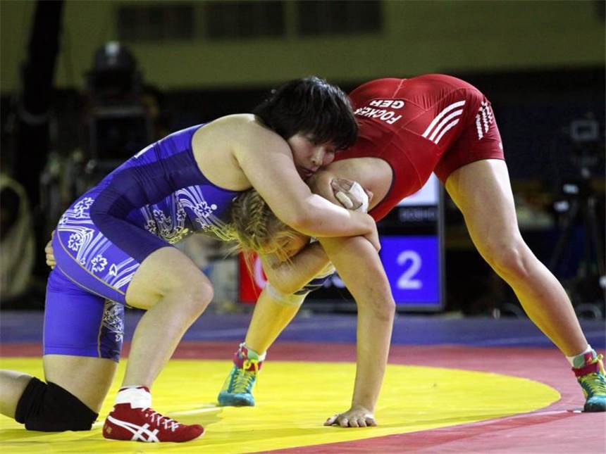 Aline Focken holt Titel bei der Ringer-WM Aline Focken (rot) stemmt sich dem Griff ihrer Gegnerin entgegen. Foto: Zurab Kurtsikidze