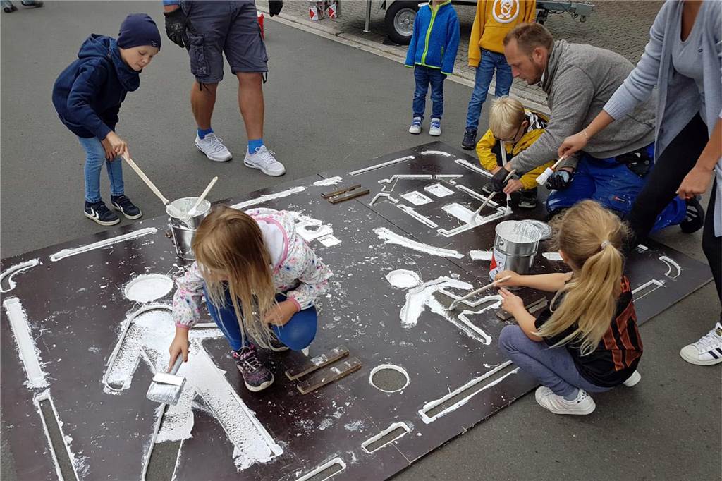 Eltern malen Tempo-Bremsen gegen Raser auf Straße Brinkhof Alle halfen mit, um das Logo Spielstraße bzw. verkehrsberuhigter Bereich aufzumalen.
