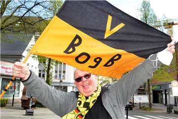 Alle Höhen und Tiefen des BVB hat die handgenähte Fan-Fahne von Martin Fischer miterlebt. Zum ersten Mal schwenkte sie sein Vater vor genau 55 Jahren beim Europokal-Triumph in Glasgow. Nur für den Moment der Aufnahme hat der Schwerter die Corona-Maske abgesetzt.