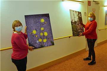 Alltagsbegleiterin Elke Luhmann-Finke (l.) und Hausleiterin Nicole Fischer zeigen die neuen Bilder und Fotos in den Fluren des Malteserstifts.