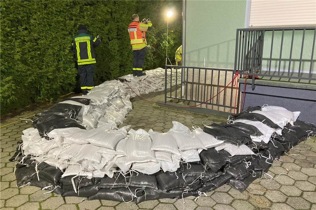 Feuerwehr und THW sichern Haus mit Sandsäcken: Hochwasser bei Ehepaar In einem Bogen aufgeschichtete Sandsäcke liegen vor dem Kellereingang eines Wohnhauses in Waltrop.