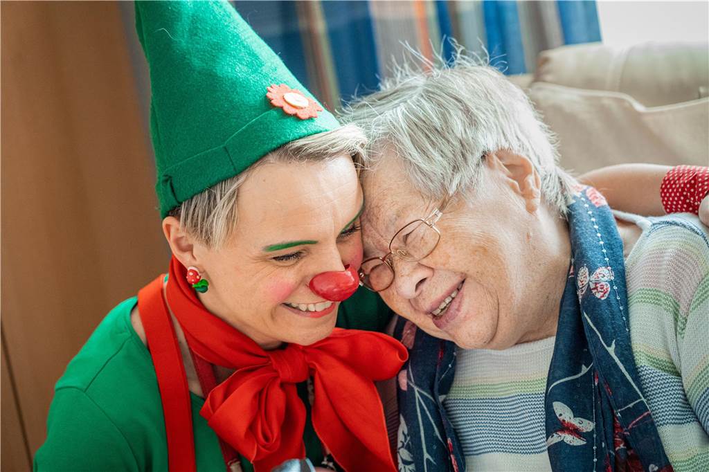 XXXXXXXXXXX Ein Therapieclown und eine Seniorin sind "Stirn-an-Stirn" miteinander.