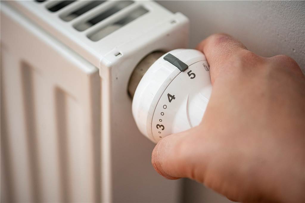 Strom sparen: Das sind die 10 größten Stromfresser im Haushalt – und so entschärft man sie Eine Person macht eine Heizung an.