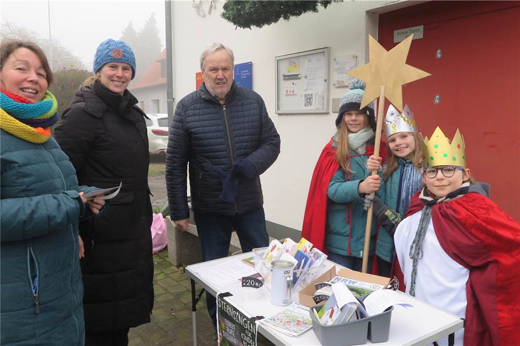 Erwachsene am Stand der Sternsinger