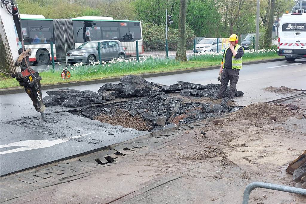 Wasserrohrbruch am Busbahnhof Germania: Borussiastraße gesperrt Ein Bagger und ein Arbeiter beim Aufbrechen der Fahrbahndecke der Borussiastraße in Dortmund, unter der eine Wassertransportleitung geborsten ist.