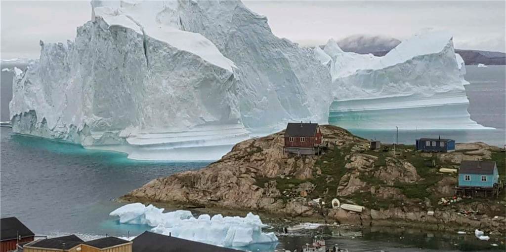 Wo der Klimawandel eine Chance ist: Grönland zwischen Schmelze und Machtspielen Ein Eisberg schwimmt vor der grönländischen Küste am Dorf Innaarsuit vorbei.