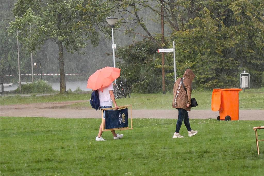 Am Nachmittag gibt es einen kräftigen Schauer, der die Besucher Schutz vor dem Regen suchen lässt.