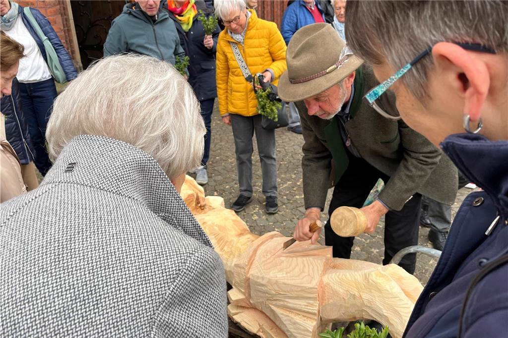 Ernst Franz beugt sich wie Zuschauerinnen über sein Kunstwerk.