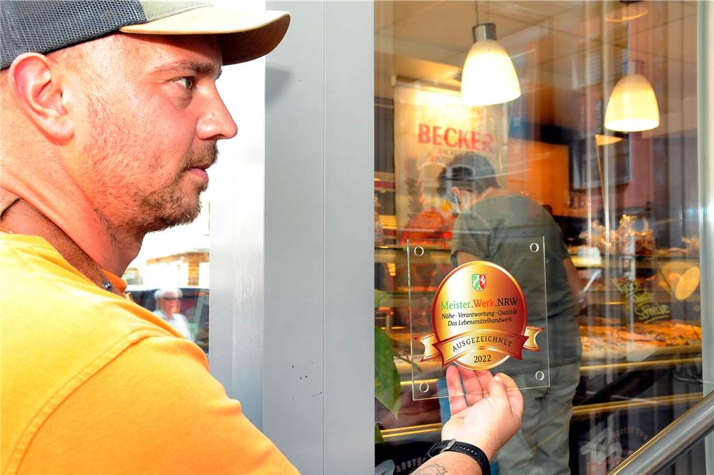 Bäcker Becker setzt auf Regionales: Nur noch Eier und Dinkel aus Ergste Am Schaufenster seiner Zentrale an der Bahnhofstraße sucht Bäckermeister Sascha Ruhnke nach dem passenden Ort für die Plakette, die seinem Betrieb mit dem Ehrenpreis des Landes NRW verliehen worden ist.