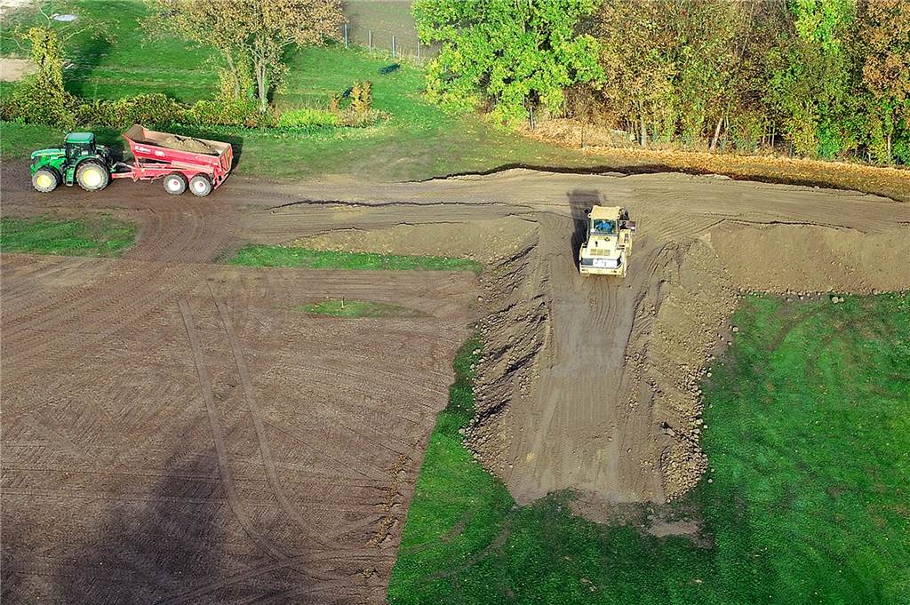 Am Südost-Ende der Sportanlage bauen die Arbeiter einen Wall.