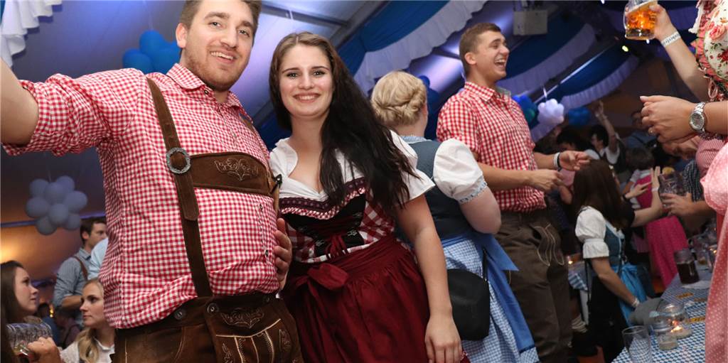 Oktoberfest in Olfen: Kostet eine Maß Bier so viel wie in München? Ein Mann in Leserhosen und eine Frau im Dirndl feiern auf dem Olfener Oktoberfest im vergangenen Jahr.