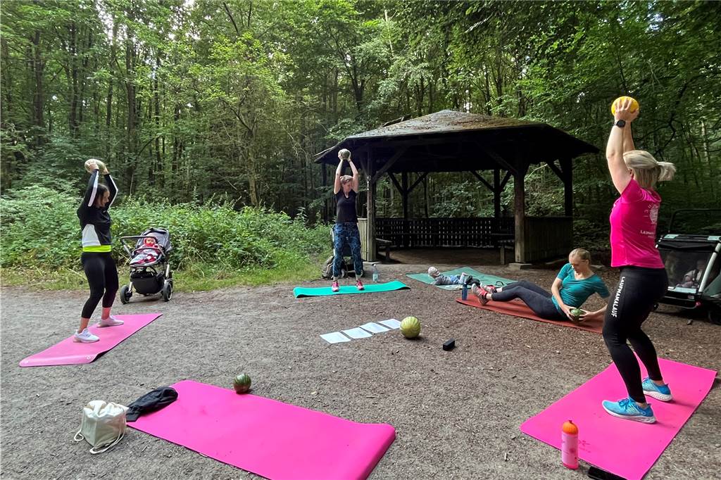 Mit dem Kinderwagen durch den Wald: Lisa Steinke (34) bietet Outdoor-Kurse für junge Mütter an Pinke Sportmatten im Kreis im Wald. Die Mütter trainieren darauf mit Wassermelonen als Gewicht