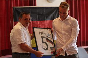 Amos Pieper (r.) hat seiner Heimat und Bürgermeister Dietmar Bergmann (l.) ein unterschriebenes Trikot mitgebracht.