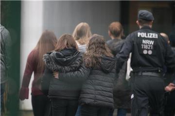 Am Tag der Tat in Lünen: Polizisten begleiten Kinder über den Pausenhof der Käthe-Kollwitz-Gesamtschule. Foto: Bernd Thissen