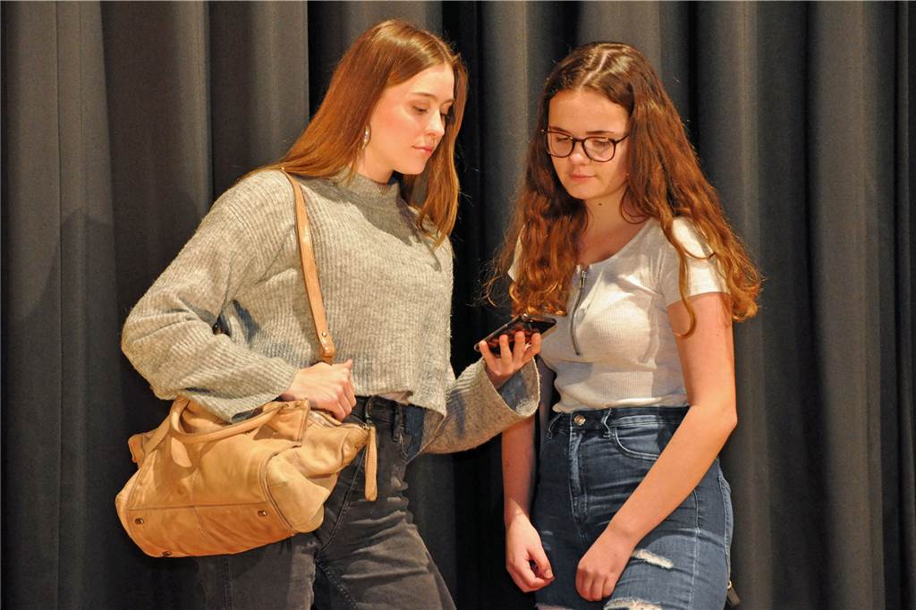 Amy (Aileen Busch, r.) und Janet (Rosa Schmidt) checken die Smartphone-News.