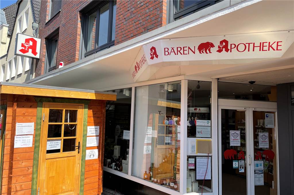 Testzentren in Haltern: Was passiert, wenn die Testpflicht entfällt? Ladenfront der Bären-Apotheke mit ausgelagerter Teststelle in einer Hütte.