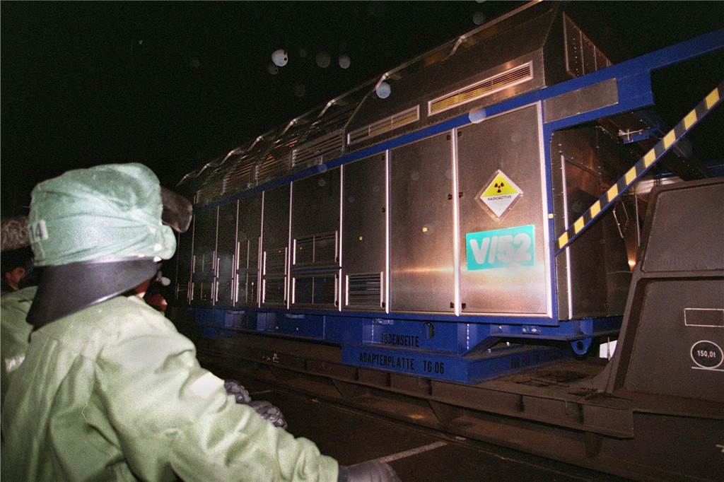 An einem Polizisten vorbei fährt am Abend des 20.03.1998 einer der Castor-Behälter in das Stadtgebiet von Ahaus. Der Zug mit insgesamt sechs Castor-Behältern traf gegen 19.25 Uhr vom Süden her in der Stadt ein. Der für dieses Frühjahr erwartete Castortransport in das Brennelemente Zwischenlager Ahaus (BZA) rollt voraussichtlich in der ersten Märzhälfte durch Deutschland. Wegen des Transportes haben Polizisten in Nordrhein-Westfalen in dieser Zeit eine Urlaubssperre, teilte ein Sprecher des NRW-Innenministeriums am Mittwoch (03.01.2001) mit. dpa +++ dpa-Bildfunk +++