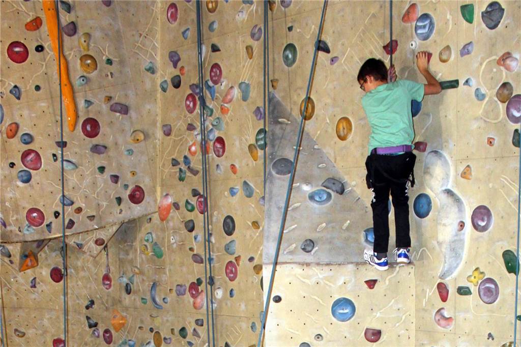 Sommerferien und Regen: Hier gibt es trotzdem Action und Spaß Kind klettert an Kletterwand