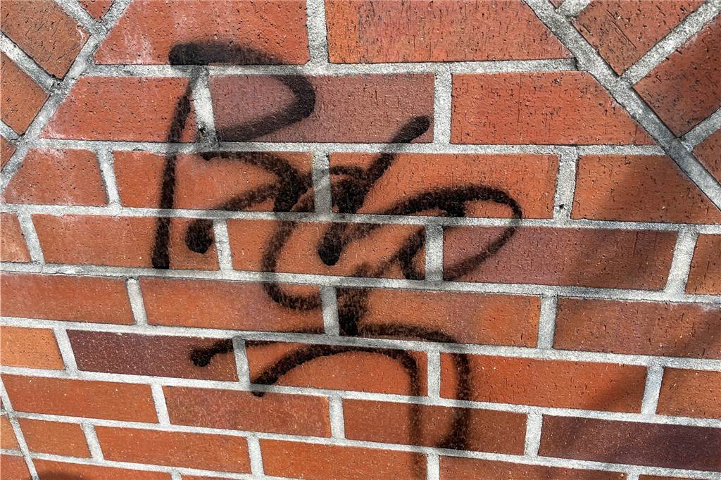 Rolf Linker ärgert sich: Sein Haus und noch andere mit Graffiti besprüht Schriftzug "Bebo" auf rotem Backstein