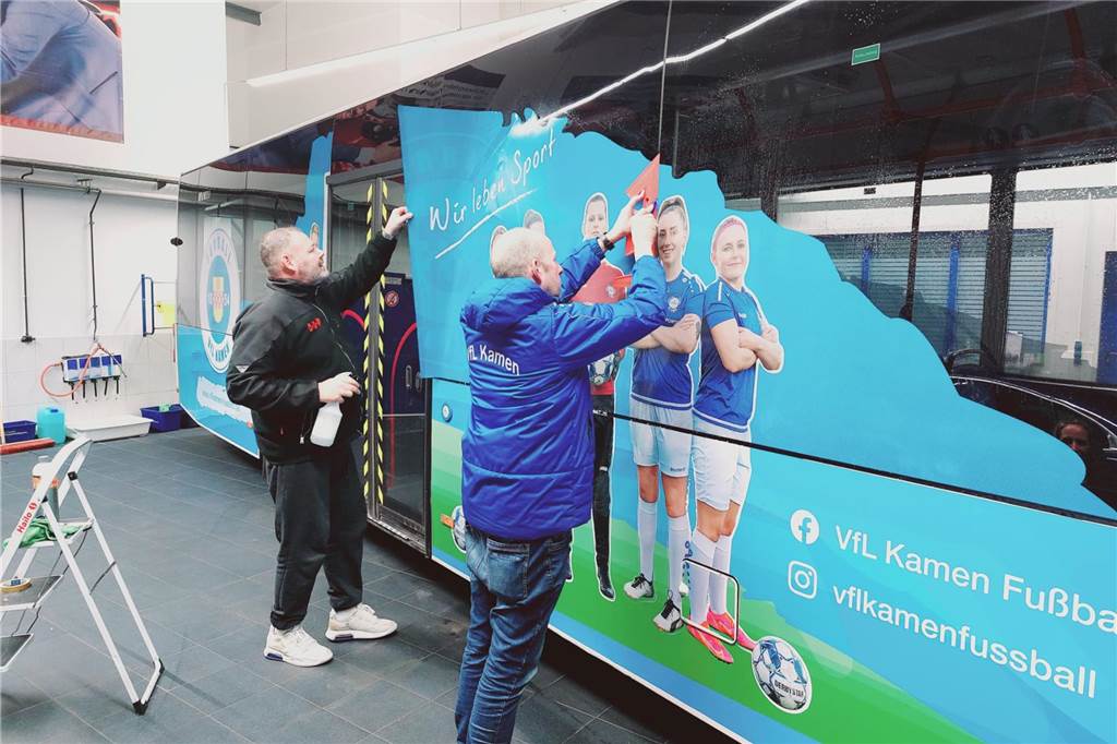 VfL Kamen auf großer Werbefahrt: Bus der VKU mit Vereinsfolie beklebt Andreas Conradi und Marco Bojda bekleben den Bus mit der VfL-Folie.