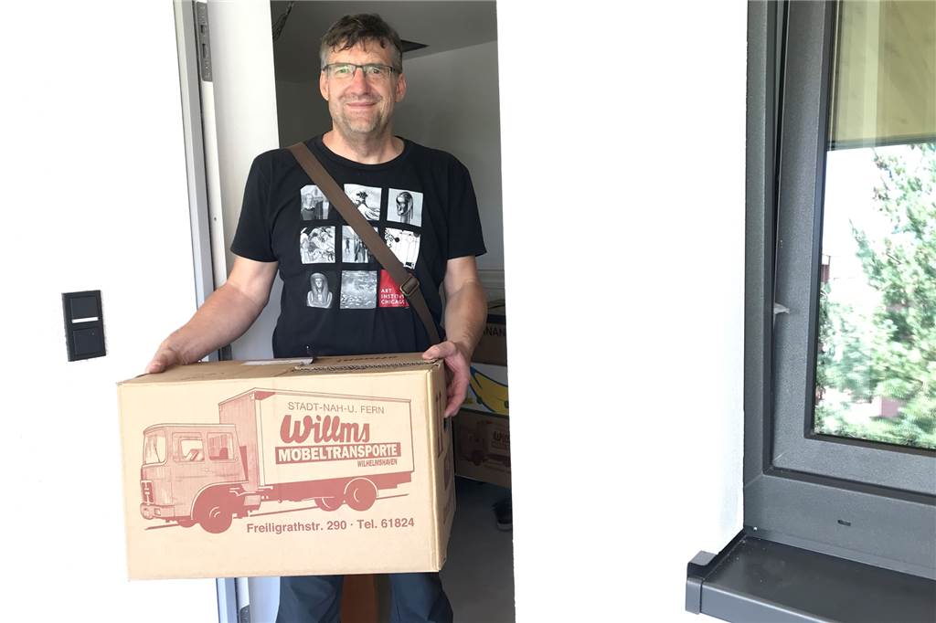 Klimaschutzsiedlung in Werne: Erste Bewohner sind schon eingezogen Andreas Drohmann trägt einen Karton in seine neue Wohnung.