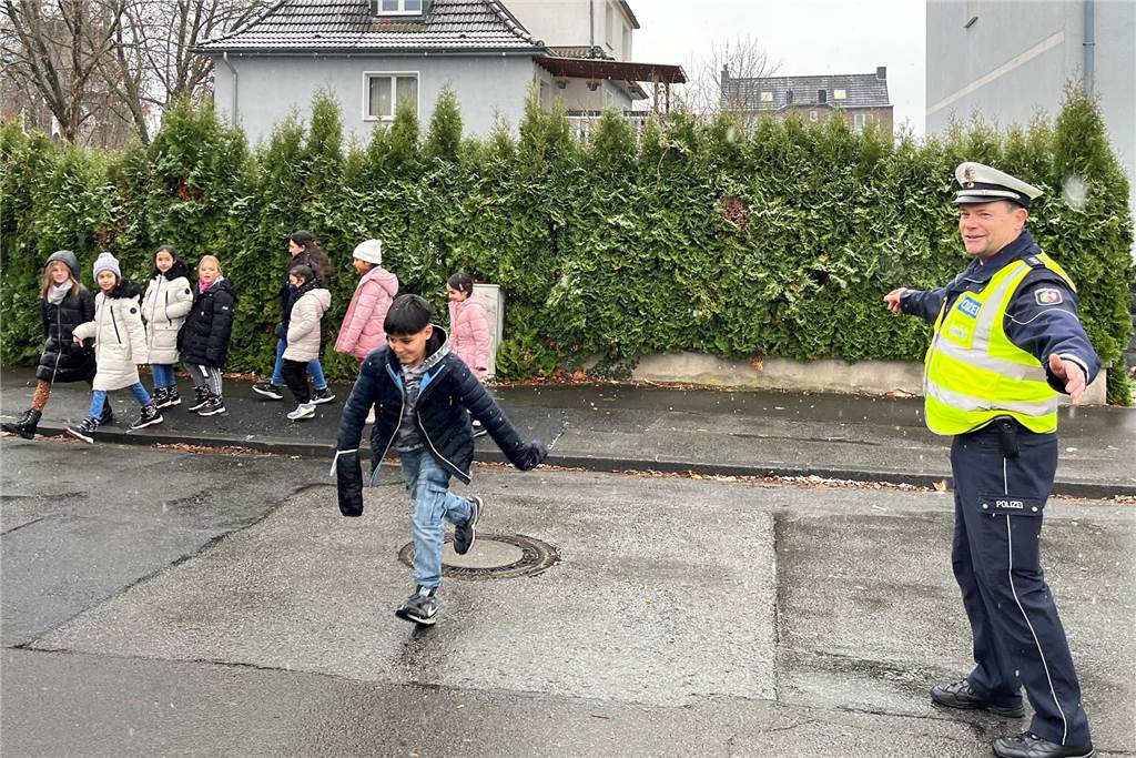 Führerschein für Fußgänger: Andreas Schlüter erklärt Kindern den Verkehr Andreas Schlüter sperrte kurzzeitig den Verkehr, sodass die Schulkinder wieder sicher zurück auf den Schulhof der Overbergschule kamen.