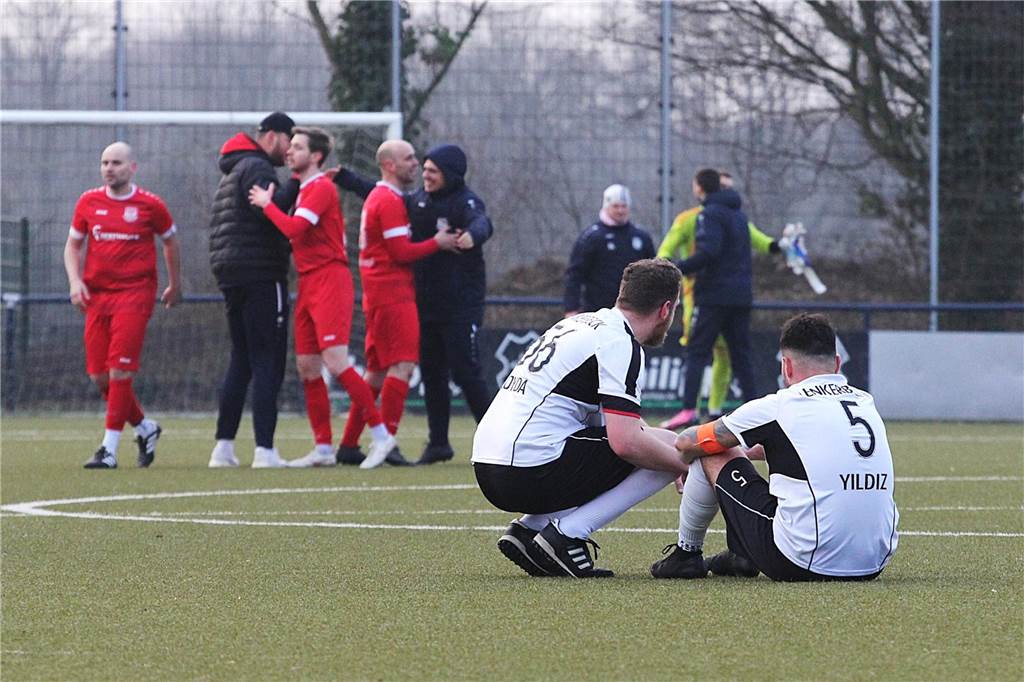 Spieler von DJK Germania Lenkerbeck gucken nach Topspiel-Niederlage traurig Richtung Flaesheimer Spieler, die gerade gewonnen haben.