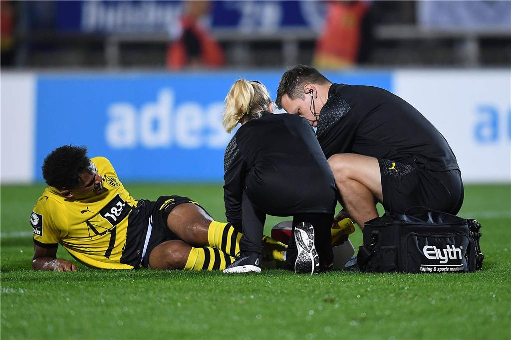 Paul Besong beendet Leidenszeit bei BVB-U23 : „Ein Glücksgefühl, als hätte ich ein Tor geschossen“ Paul Besong liegt auf dem Rasen und wird von Physiotherapeut Daniel Zolinski behandelt.